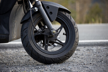 a scooter tire in front of a street
