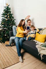Obraz premium Happy family in sofa, yellow gray colors.