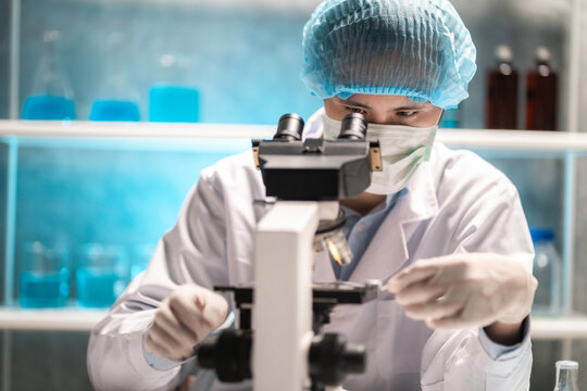 scientist looking through scientific microscope lense in laboratory, scientist doing research in term of medicine biotechnology biology or chemistry, doctor analyzing work in medical microbiology lab