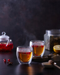 Hot tea with cranberries on a dark background