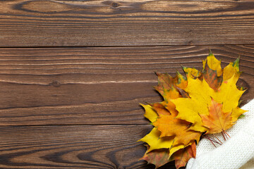 Bouquet of yellow maple leaves over brown wooden backgound copy space, flat lay. Autumn herbarium.