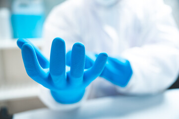 Closeup of hands of a young unrecognizable scientist, researcher and doctor wearing blue hand...