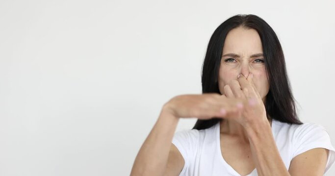 Young woman covering nose and waving hand 4k movie