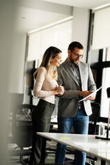 Colleagues in office. Businesswoman and businessman discussing work in office.