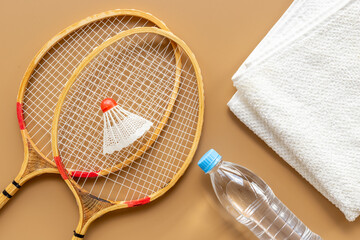 Competitive sports equipment. Two badminton rackets and shuttlecock with towel and water