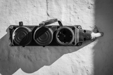 Old black electrical outlet on a white wall