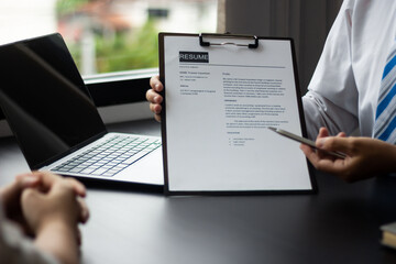 Manager holding resume of applicants who are interviewing for an accounting position at a company, HR manager reviewing job applicants' resumes, job interview ideas and recruiting.