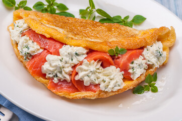 Omelet with lightly salted salmon and cream cheese and fresh herbs.