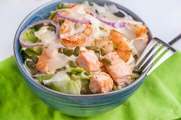 Baked salmon fillet salad with fresh vegetables and cheese.