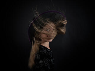 A girl dressed as a witch and a wide-brimmed hat for Halloween.