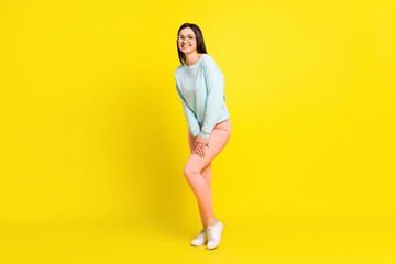 Fototapeta na wymiar Full body photo of cute brown hairdo young lady stand wear spectacles blue hoodie trousers isolated on yellow color background