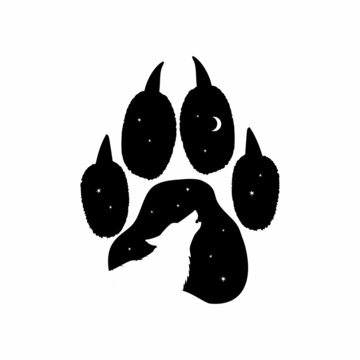 The silhouette of a wolf against the background of the forest at night in the imprint of a wolf's paw