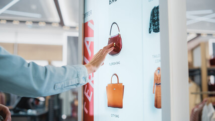 Beautiful Female Customer Using Floor-Standing LCD Touch Display while Shopping in Clothing Store....