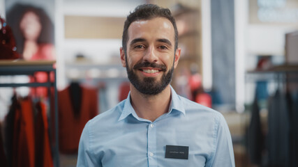 Portrait of a Happy Handsome Store Assistant in Blue Shirt Smiling and Posing for Camera at...
