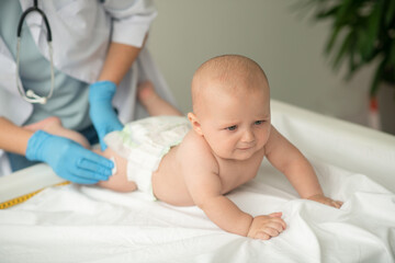 Baby being prepared for a thigh injection