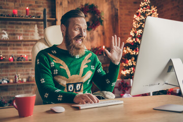 Photo of positive freelancer bearded ginger man sit desk wave hand conference wear sweater...