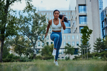 Fit young sportswoman running in the park