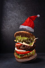 burger in santa hat flying food on dark background