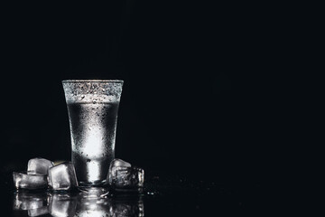 Vodka. Shots, glasses with vodka with ice .Dark background. Copy space .Selective focus