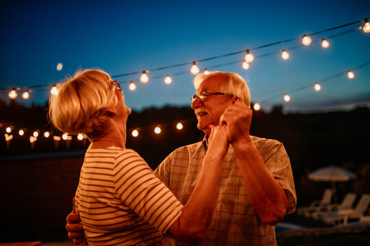 Romantic senior couple having fun while dancing outdoors