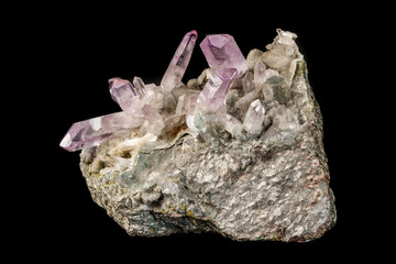 Macro mineral stone Amethyst crystals in rock on a black background
