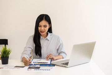 Businesswoman analyzing and brainstorming data, charts, financial reports in the office with laptop and calculator. Ideas for working with financial and investment accounts.
