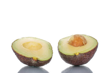 Two halves of organic ripe avocado, close-up, isolated on white.