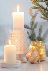 Christmas decorations with burning candles in white interior