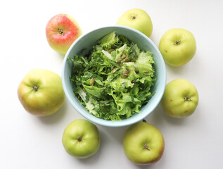 fresh salad leaves with pumpkin seeds in a plate, close-up and green apples. Comfortable digestion, proper nutrition, weight loss. The texture of vegetables, salad. Seasonal vitamins, fiber