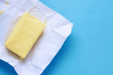 slice of a butter on a paper on table 