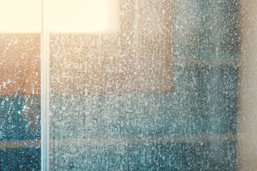 Removing hard water stains and deposits in bathroom. Stains drops on glass shower doors - obrazy, fototapety, plakaty