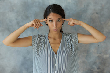 Horizontal image of attractive Caucasian indignant woman with dark hair wearing casual clothes...