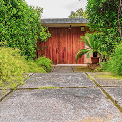 modern family house external entrance through the garden to solid wood door