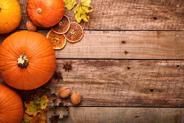 Pumpkin. Autumn food background with cinnamon, nuts and seasonal spices on rustic background. Cooking pumpkin or apple pie and cookies for Thanksgiving and autumn holidays. Top view with copy space.