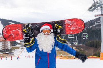 a man in a santa hat with a snowboard at a ski resort