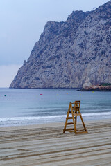 Lifeguard wooden chair next to large cliff. Calpe Alicante.