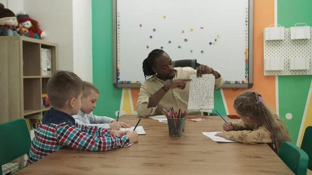 African American teacher teaches a group of children in a classroom. School for Children, Teaching Adolescents, Gain Knowledge, Learn the Language.