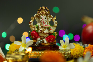 Front view of Statue Of Hindu God Ganesha Ganpati Sitting On Golden Asana With Fruits, Flowers,...
