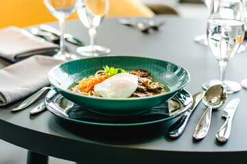 Beef ramen soup with poached egg and vegetables at a restaurant