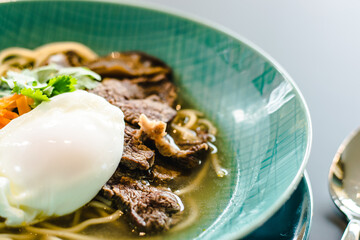 Beef ramen soup with poached egg and vegetables at a restaurant