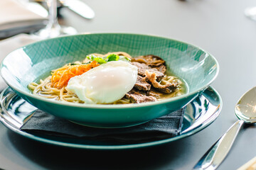 Beef ramen soup with poached egg and vegetables at a restaurant