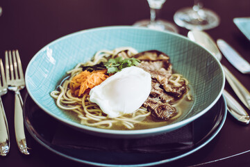 Beef ramen soup with poached egg and vegetables at a restaurant