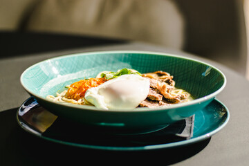Beef ramen soup with poached egg and vegetables at a restaurant