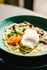 Beef ramen soup with poached egg and vegetables at a restaurant