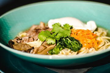 Beef ramen soup with poached egg and vegetables at a restaurant