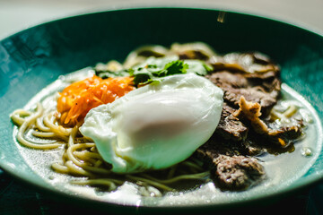 Beef ramen soup with poached egg and vegetables at a restaurant
