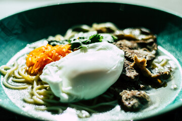 Beef ramen soup with poached egg and vegetables at a restaurant