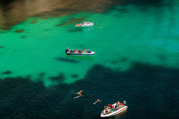 Fototapeta premium Boats in azure water, top view. Sea or ocean water. Sevastopol, Crimea - 8 Sep 2021