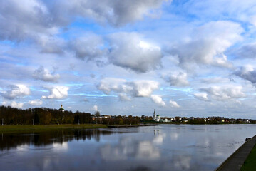 Obraz premium Beautiful autumn city landscape with view of river. Clouds are reflected in water on sunny day. Distance is Catherine Monastery. Tver. Russia