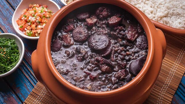 Typical Brazilian dish called Feijoada. Slide shot with smoke. Top View